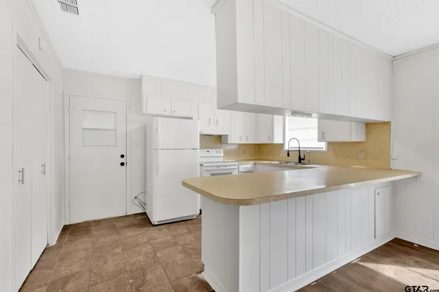 a kitchen with a sink appliances and cabinets