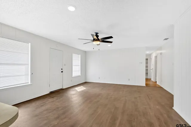 a view of empty room with wooden floor and window