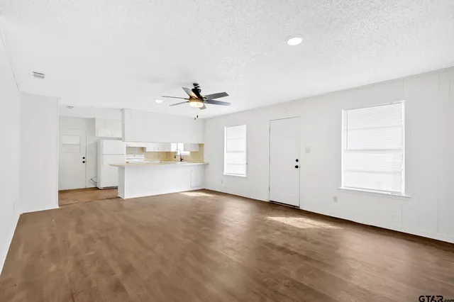 a view of an empty room with wooden floor
