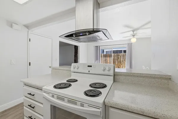 a kitchen with a stove and a white cabinets