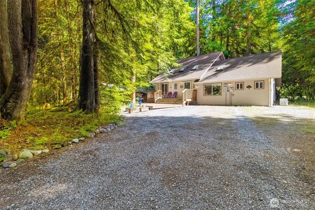a big house with large trees and wooden fence