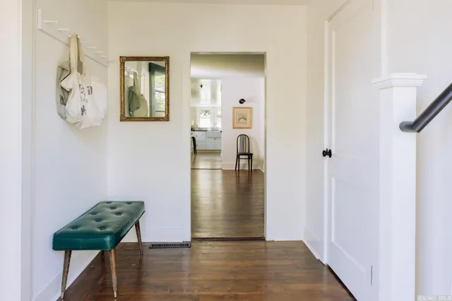 a view of a hallway with wooden floor and a dining room