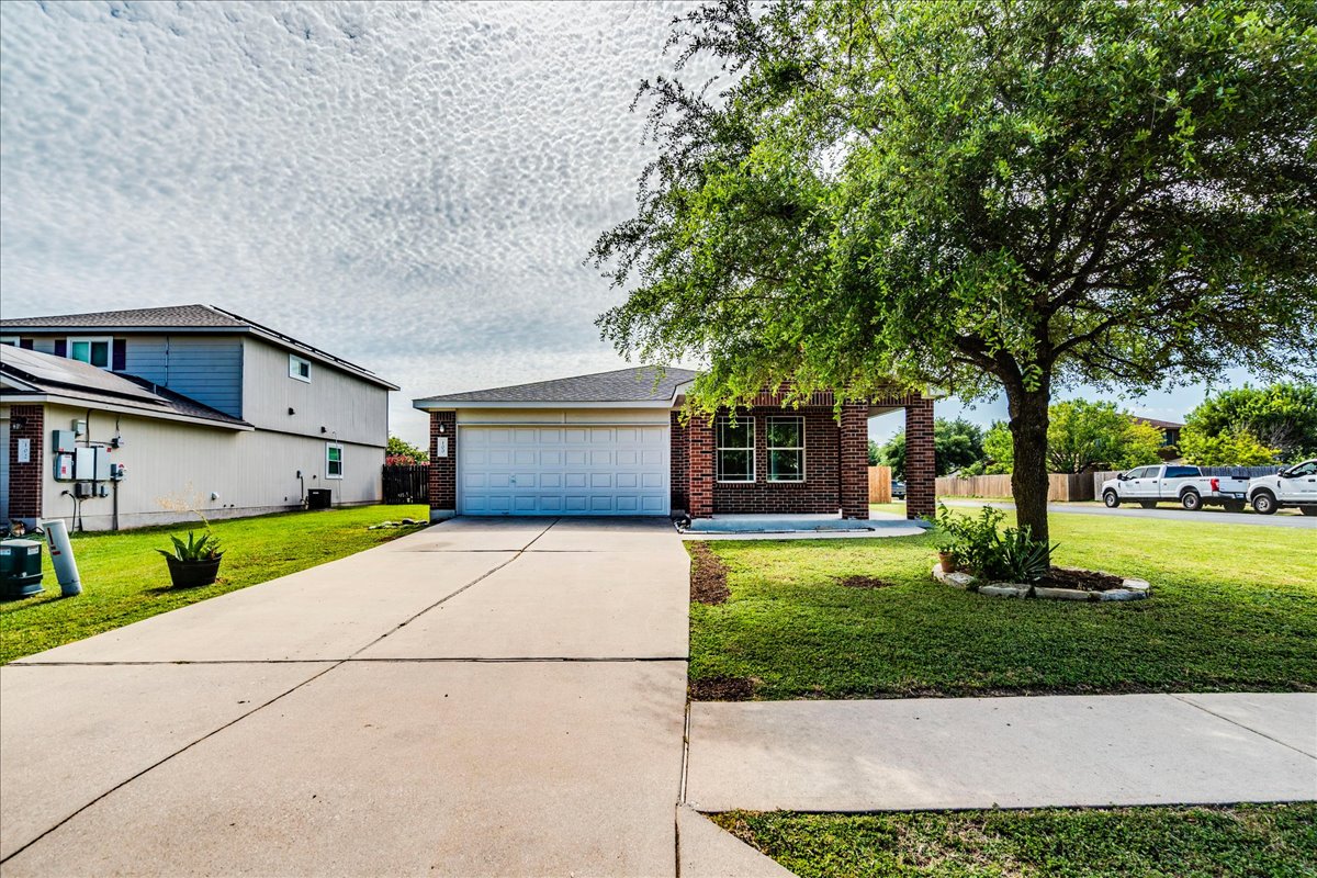 100 Easy Street Hutto, TX 78634 - Photo 35 of 36 A classic brick exterior and well-maintained lawn welcome you home, complete with a convenient concrete driveway.
