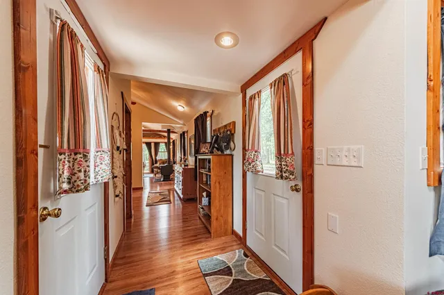 a view of a hallway with wooden floor and stairs