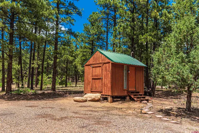 a view of a house with backyard and trees