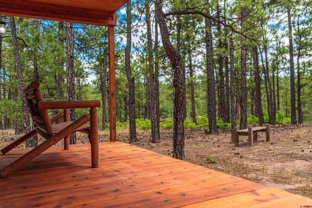 a wooden bench with trees in the background