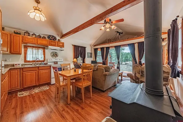 a view of a dining room with furniture a chandelier and wooden floor