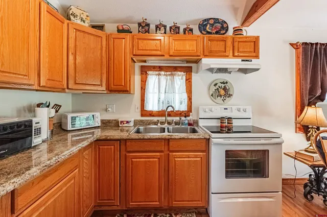 a kitchen with stainless steel appliances granite countertop a stove a sink and a microwave