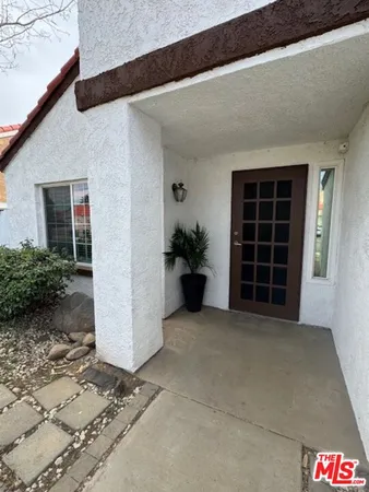a view of front door with potted plants