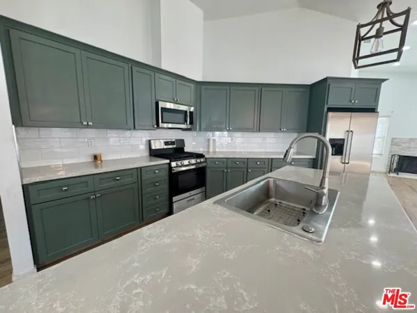 a kitchen with a sink a stove and cabinets