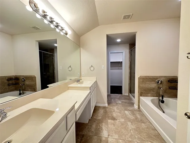 a large bathroom with a large tub shower and sink