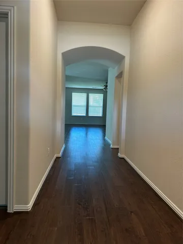 a view of a hallway with wooden floor and a living room