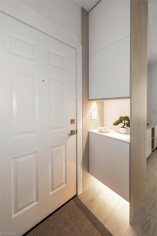 1170 Reserve Way, Unit 107 Naples, FL 34105 - Photo 7 of 47 Doorway to outside featuring wood finished floors