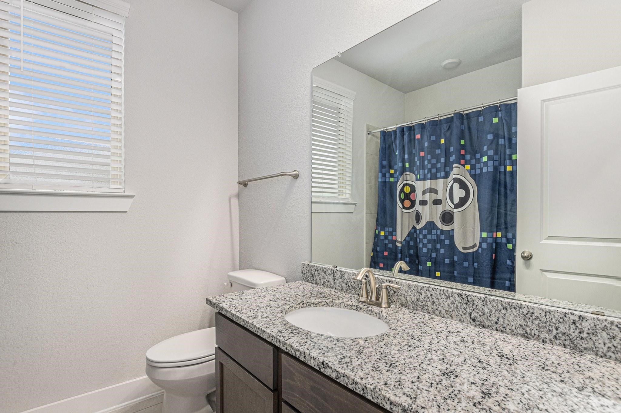 1818 Homewood Point Lane Rosharon, TX 77583 - Photo 28 of 41 a bathroom with a granite countertop sink a toilet and a mirror