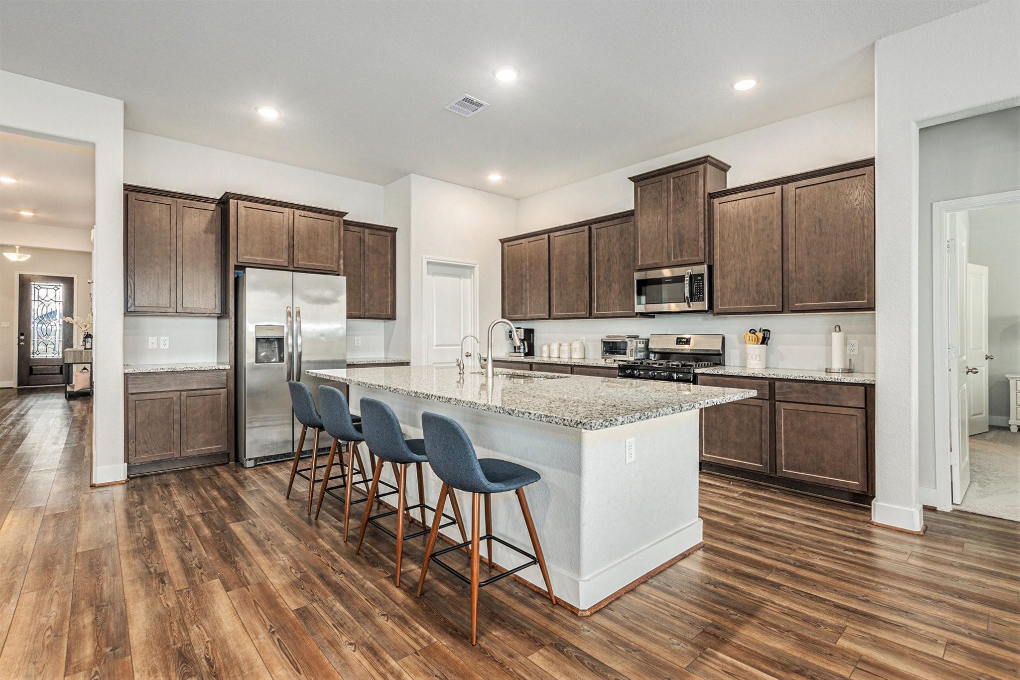 1818 Homewood Point Lane Rosharon, TX 77583 - Photo 5 of 41 a kitchen with stainless steel appliances granite countertop a refrigerator a stove top oven a sink dishwasher and a refrigerator with wooden floor