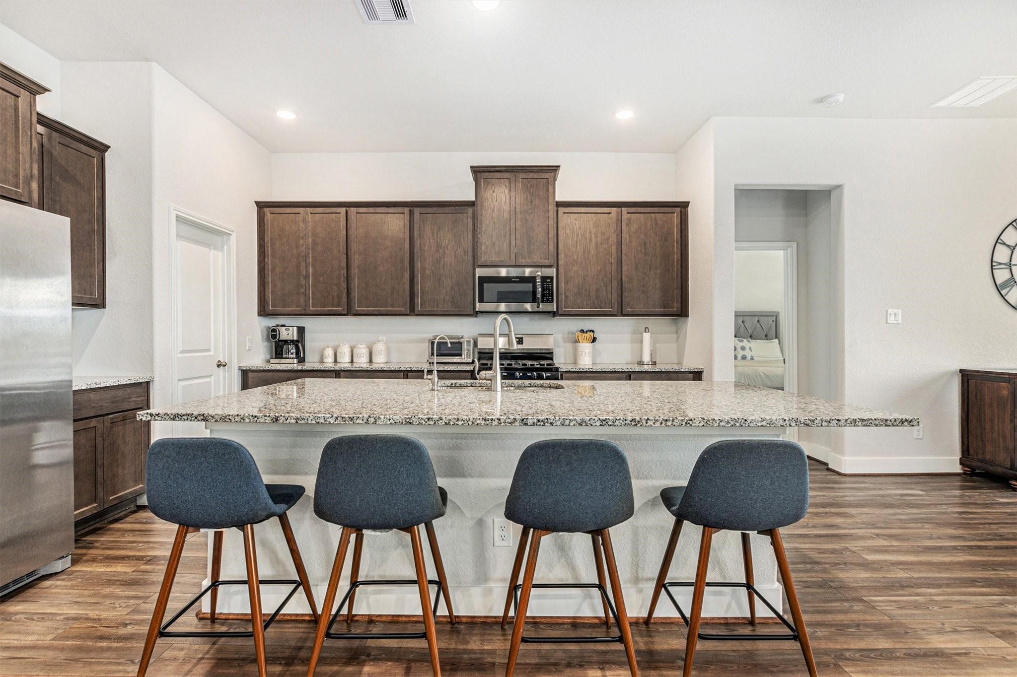 1818 Homewood Point Lane Rosharon, TX 77583 - Photo 6 of 41 a kitchen with stainless steel appliances granite countertop a stove a refrigerator a dining table and chairs with wooden floor