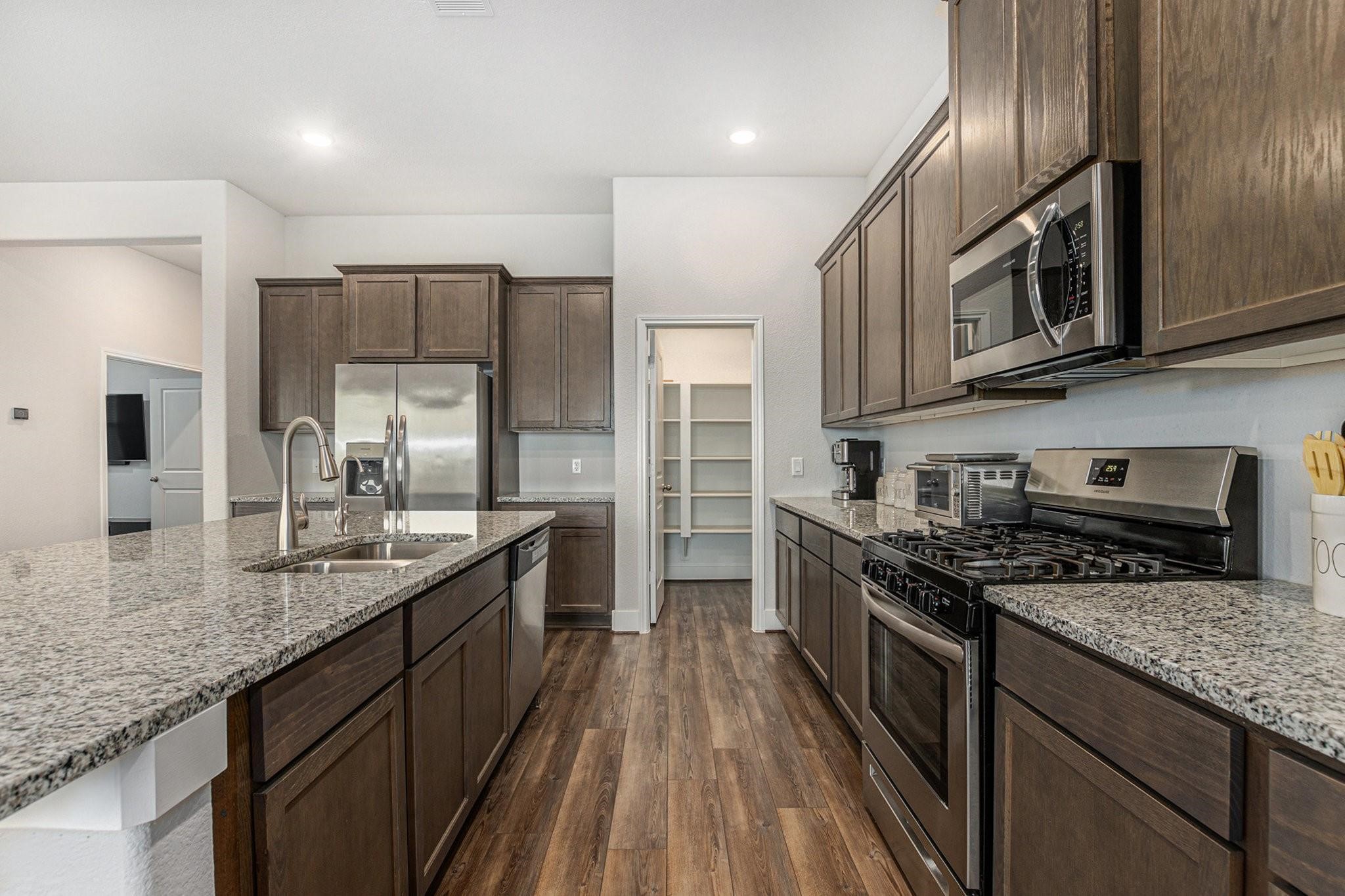 1818 Homewood Point Lane Rosharon, TX 77583 - Photo 9 of 41 a kitchen with stainless steel appliances granite countertop a stove a sink and a microwave