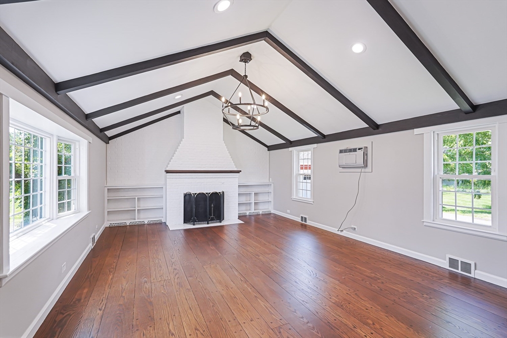 11 Millville Road Mendon, MA 01756 - Photo 4 of 28 an empty room with wooden floor fireplace and windows