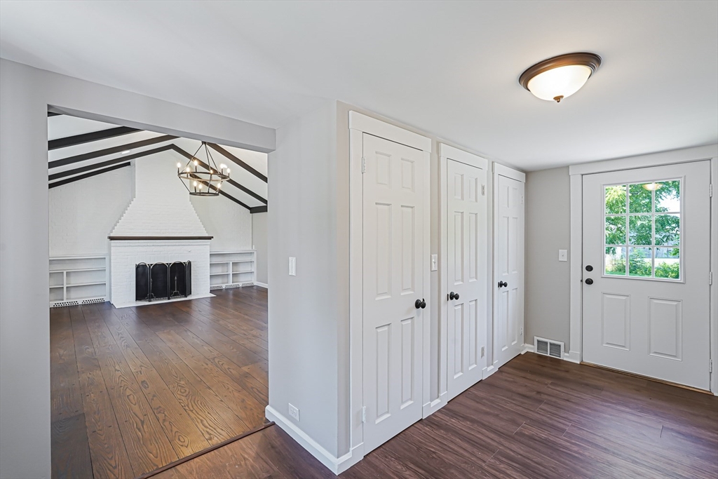 11 Millville Road Mendon, MA 01756 - Photo 5 of 28 an empty room with wooden floor fireplace and windows