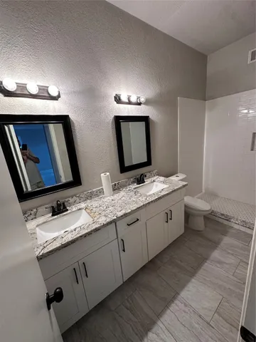 a bathroom with double sink and a mirror
