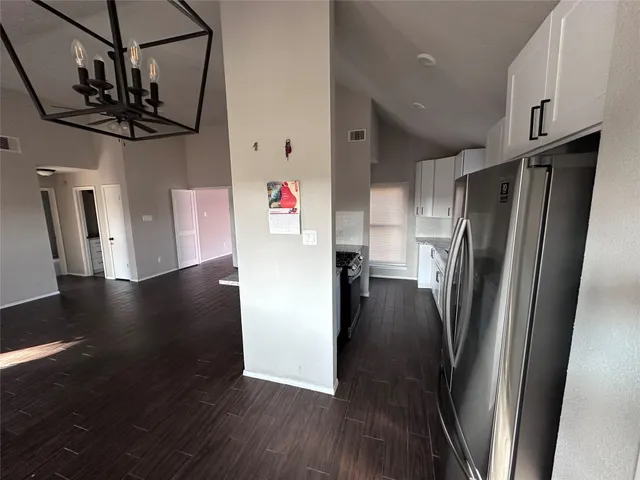 a kitchen with stainless steel appliances a refrigerator and wooden floor