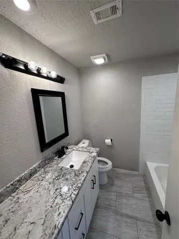 a bathroom with a sink a toilet and mirror