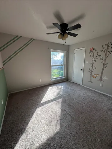 a view of a livingroom with a ceiling fan and window