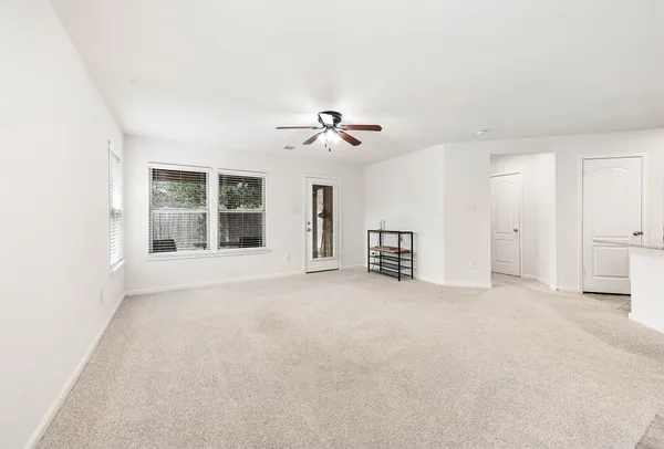 an empty room with ceiling fan and window
