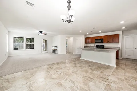 a large white kitchen with stainless steel appliances granite countertop a large counter top and a stove top oven