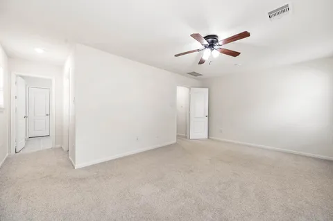 an empty room with closet and ceiling fan