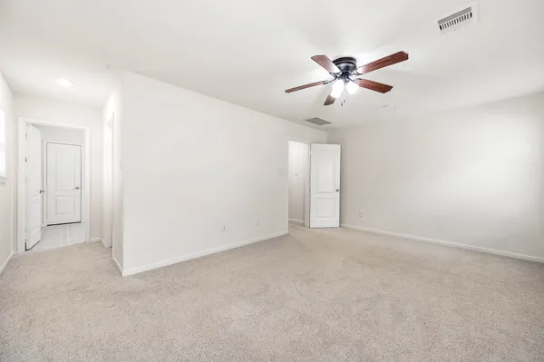an empty room with closet and ceiling fan