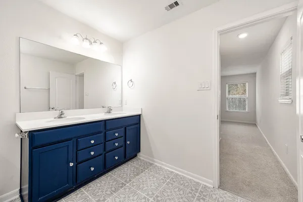 a bathroom with a double vanity sink and a mirror