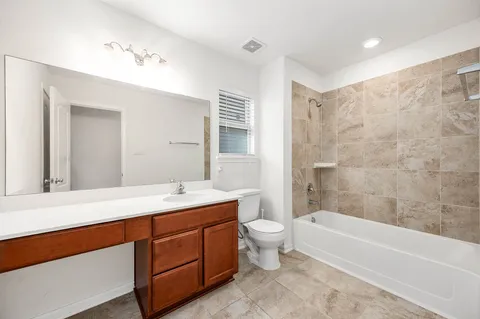 a bathroom with a double vanity sink a large mirror and a bathtub