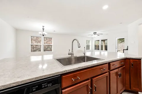 a kitchen with granite countertop a sink and a wooden floor