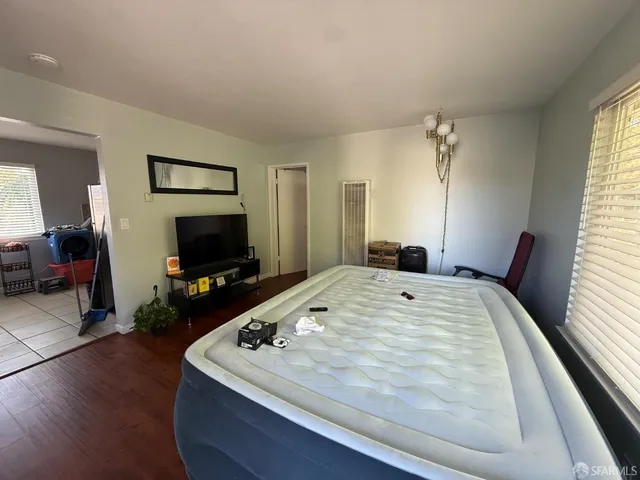 a bed sitting in a bedroom and flat screen tv