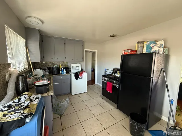 a kitchen with a refrigerator and a stove top oven