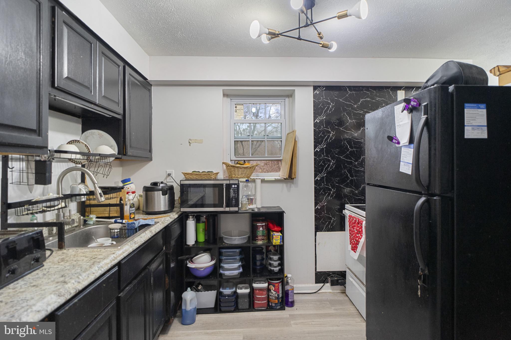 1909 Hanover Pike Hampstead, MD 21074 - Photo 22 of 32 a kitchen with stainless steel appliances granite countertop a refrigerator a stove and a sink with wooden floor