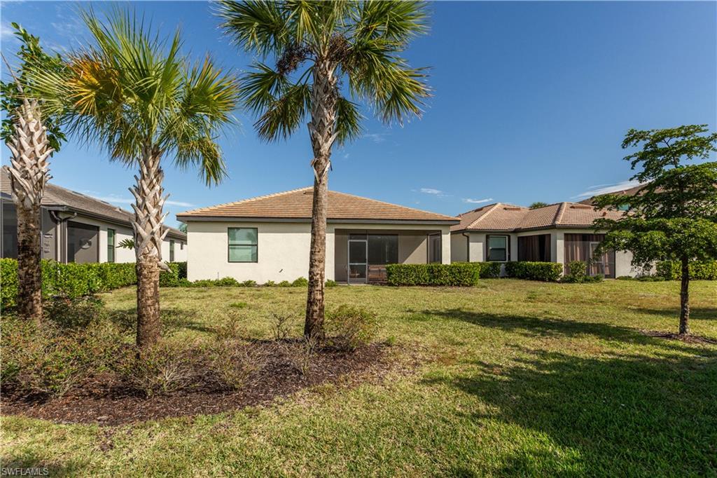 18293 Ridgeline Drive Estero, FL 33928 - Photo 28 of 47 a front view of a house with a garden