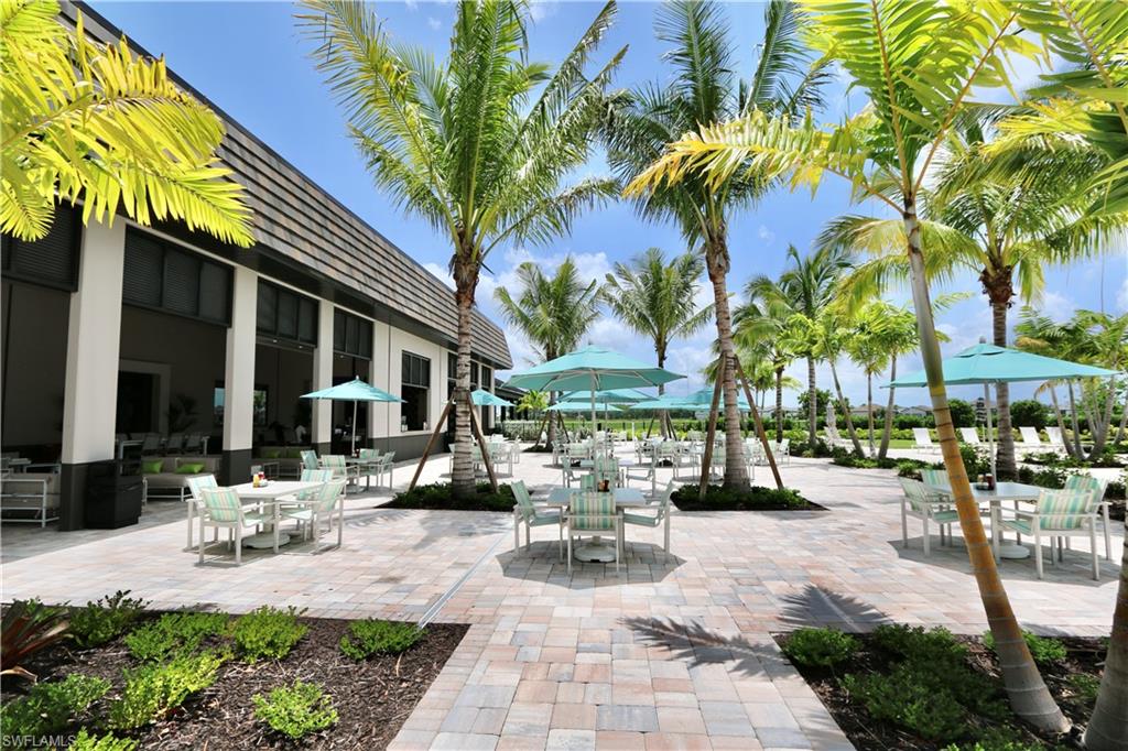 18293 Ridgeline Drive Estero, FL 33928 - Photo 38 of 47 a view of a patio with table and chairs potted plants and palm trees
