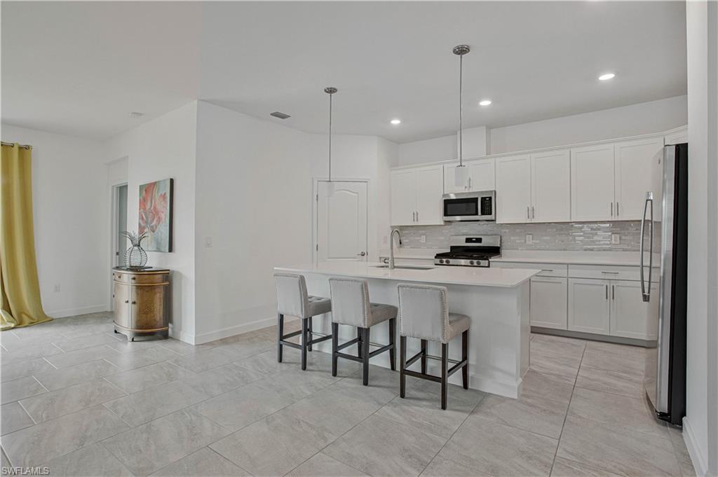 18293 Ridgeline Drive Estero, FL 33928 - Photo 8 of 47 a kitchen with appliances cabinets and chairs