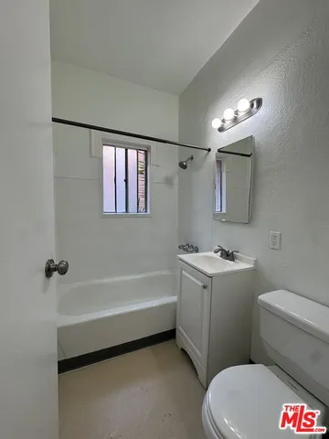 a bathroom with a sink a toilet a mirror and a bathtub