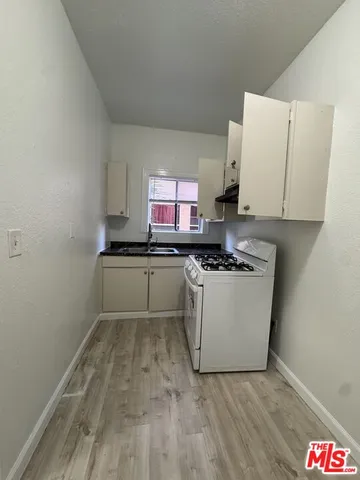 a kitchen with a sink cabinets and wooden floor