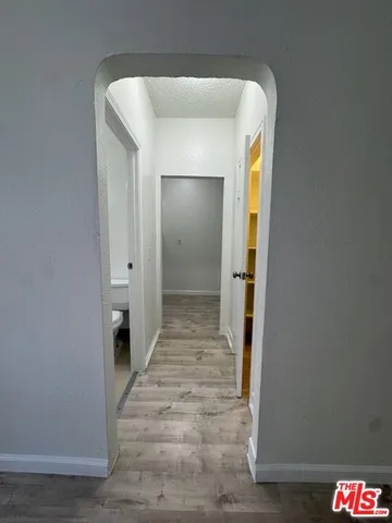a view of a hallway with wooden shelves