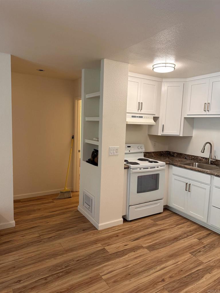 6394 Rancho Mission Road San Diego, CA 92108 - Photo 2 of 14 a kitchen with granite countertop a stove and a refrigerator