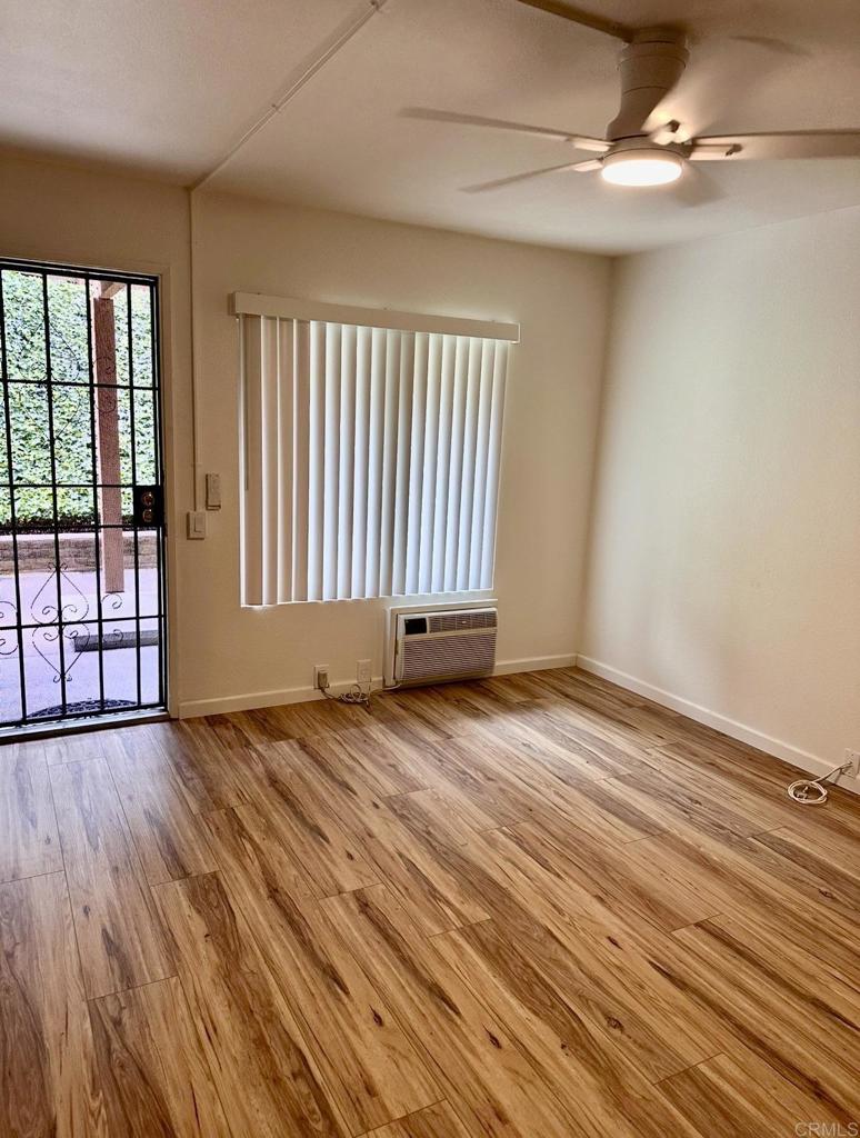6394 Rancho Mission Road San Diego, CA 92108 - Photo 3 of 14 an empty room with wooden floor and windows