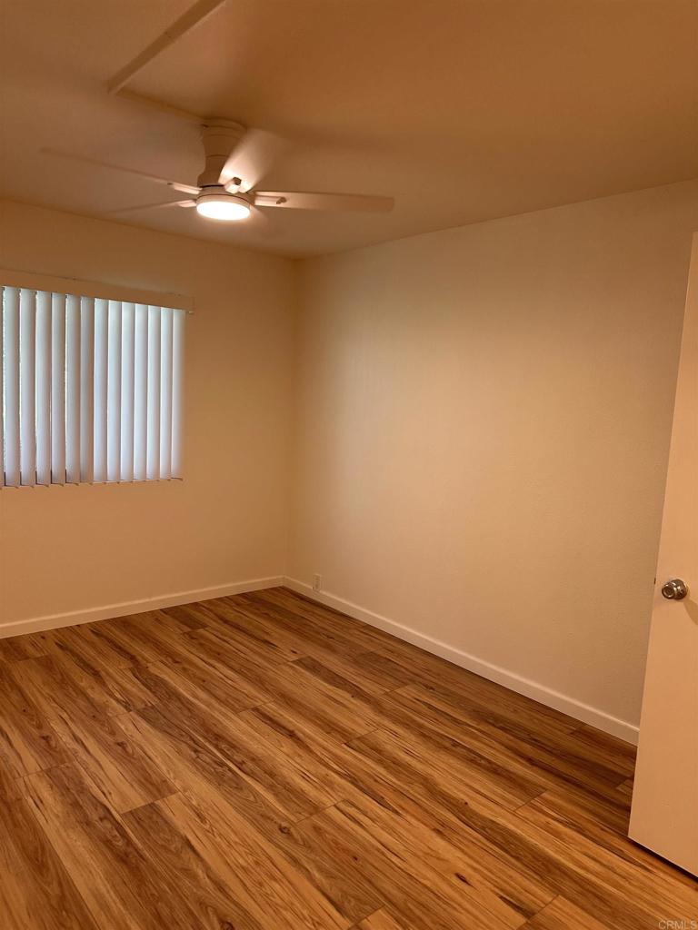 6394 Rancho Mission Road San Diego, CA 92108 - Photo 4 of 14 a view of an empty room with wooden floor and a window