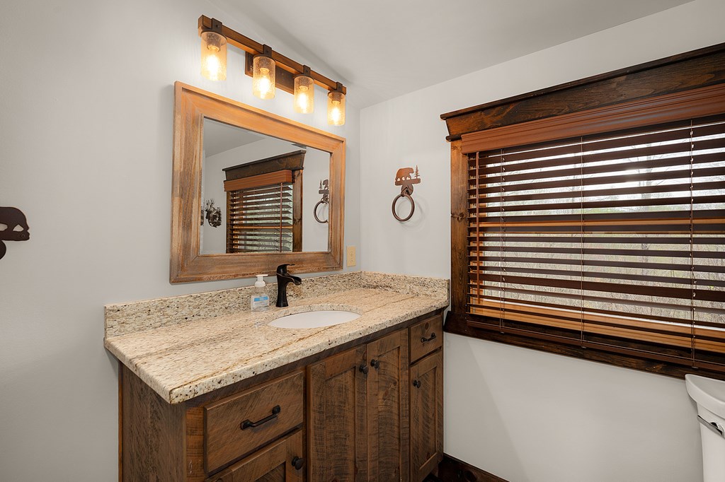 136 A Pack Creek Road Blue Ridge, GA 30513 - Photo 58 of 66 a bathroom with a granite countertop sink and a mirror