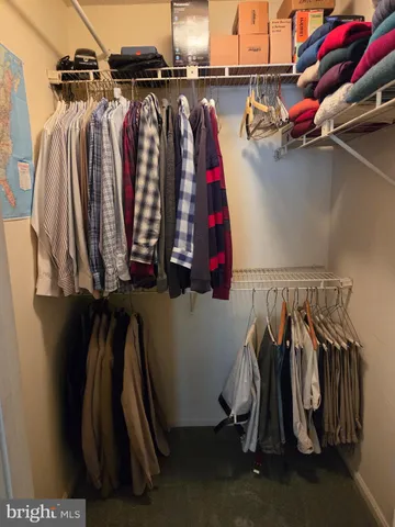 a view of walk in closet with clothes and shoes