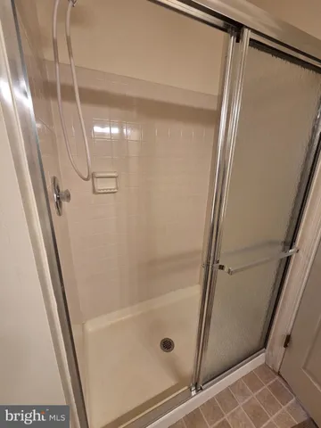 a bathroom with a glass door shower and tub
