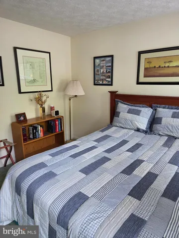 a bedroom with bed and paintings on the wall